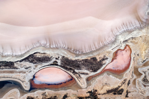 Aerial view of pink salt lake with intricate shoreline patterns - Australian Stock Image