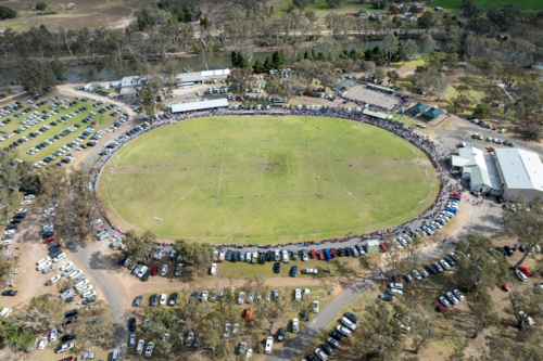 Aerial view of players and crowd at a rural Australian rules football match. - Australian Stock Image