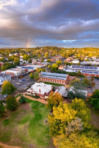 Aerial view of rainbow and cloud formations over a regional town's historic streetscape - Australian Stock Image