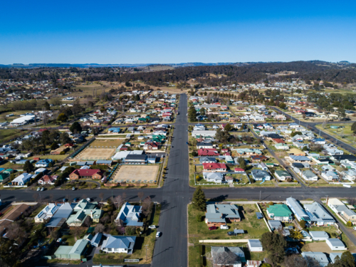 Aerial view of road out of rural town lined with homes in Glen Innes Australia - Australian Stock Image
