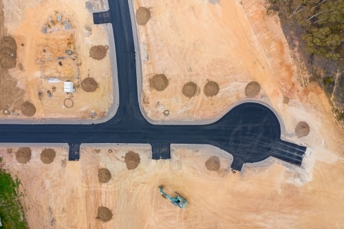 Aerial view of roads and house blocks and machinery in a new housing subdivision - Australian Stock Image