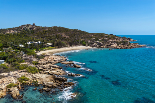 aerial view of Rose Bay in Bowen, Queensland, showcasing turquoise waters and rocky headland - Australian Stock Image