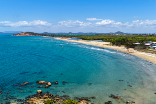 aerial view of Rose Bay in Bowen, Queensland, showcasing turquoise waters and rocky headland - Australian Stock Image