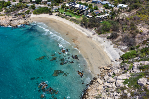 aerial view of Rose Bay in Bowen, Queensland, showcasing turquoise waters and rocky headland - Australian Stock Image