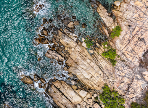 aerial view of Rose Bay in Bowen, Queensland, showcasing turquoise waters and rocky shoreline - Australian Stock Image