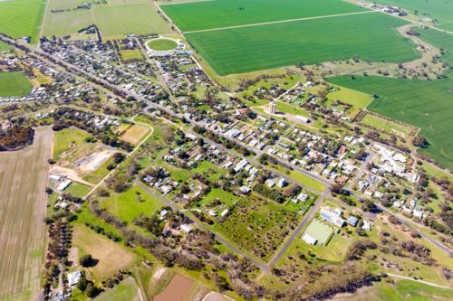 Aerial view of rural township surrounded by green farmland - Australian Stock Image