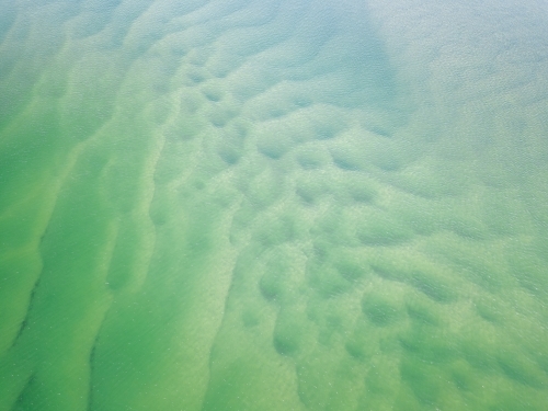 Aerial view of sand patterns in shallow blue water - Australian Stock Image