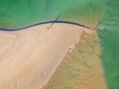 Aerial view of sandbars and waves at the mouth of a tidal river - Australian Stock Image