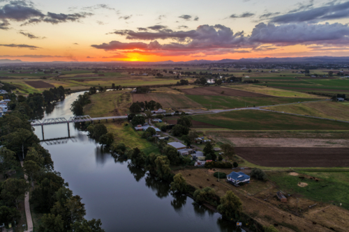 Aerial view of sunset over Morpeth River and bridge in New South Wales, Australia. Scenic landscape - Australian Stock Image