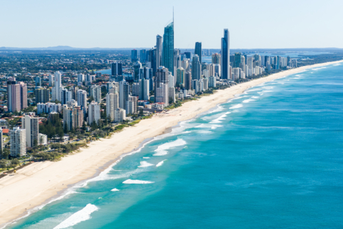 Aerial view of Surfers Paradise with high-rise buildings lining a long sandy beach. - Australian Stock Image