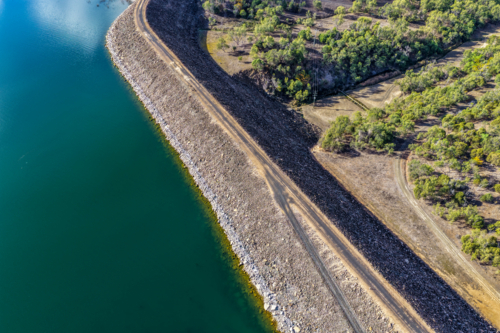Aerial view of the access road onto the Glenbawn Dam wall with surrounding landscape in NSW - Australian Stock Image
