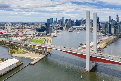 Aerial view of the Bolte Bridge over the Yarra River and Melbourne city skyline in the background - Australian Stock Image