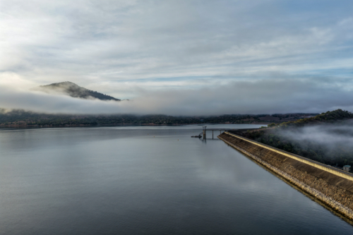Aerial view of the Glenbawn Dam wall featuring the water intake system and servicing pontoon - Australian Stock Image