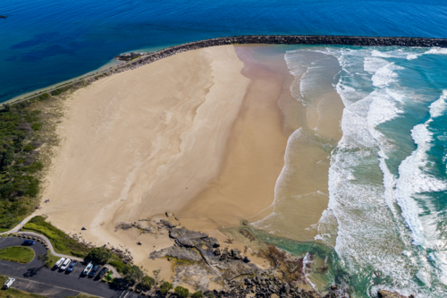 Aerial view of Turners Beach and the southern breakwall at Yamba, showing the sandy shoreline - Australian Stock Image