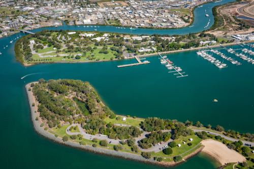 Aerial view of two islands with marina and urban coastline at sunset - Australian Stock Image