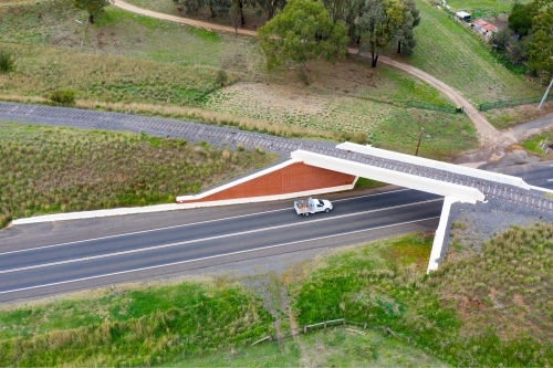 Aerial view of utility driving under a railway overpass - Australian Stock Image