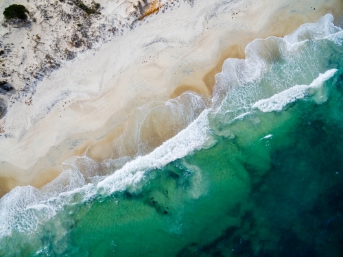 aerial view of waves washing up onto a beach - Australian Stock Image