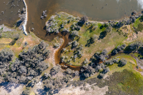 aerial view of wetland with creek entering a lake - Australian Stock Image