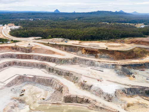 Aerial view over a quarry pit with the Glasshouse Mountains in the background - Australian Stock Image