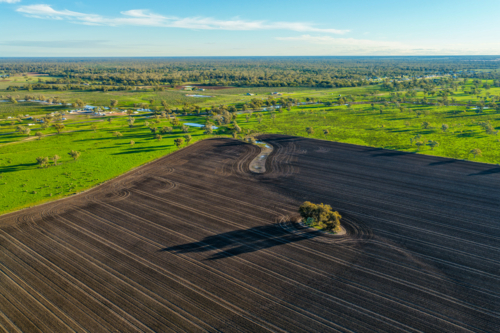 Aerial view showcasing cultivated farmland with striking patterns in the foreground - Australian Stock Image