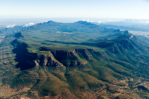Aerial views of rugged mountain range and natural amphitheatre in remote outback landscape. - Australian Stock Image