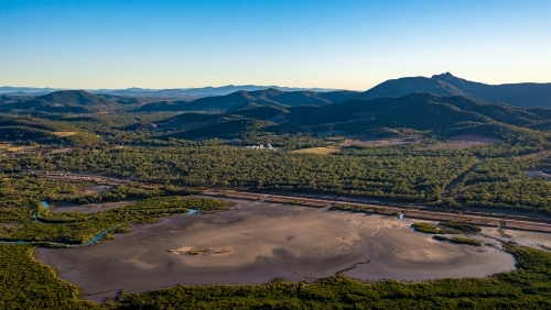 Alumina conveyor belt with mudflats in the foreground and hills in the background - Australian Stock Image