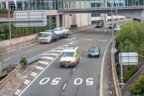 Ambulance driving along an inner-city road as seen from an overpass - Australian Stock Image
