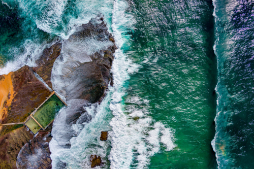 An abstract overhead of the waves crashing onto the rock platform at Mona Vale rock pool - Australian Stock Image