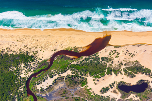 An aerial of Crockers Creek reaching the ocean at Redhead Beach - Australian Stock Image