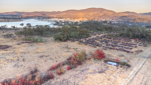 An aerial scene on a winter's morning over a dam, a junkyard and a mountain - Australian Stock Image