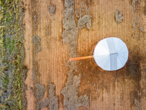 An aerial view of a grain bin in a bare paddock - Australian Stock Image