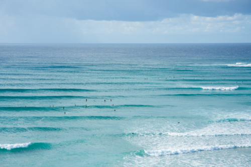 An aerial view of surfers waiting for a wave in the ocean - Australian Stock Image
