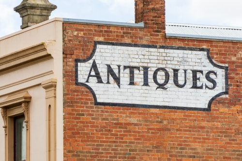 An antique sign painted onto the side of a brick wall of an historic building - Australian Stock Image