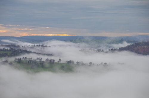 An early morning country scene underneath dawn skies with a low lying mist - Australian Stock Image
