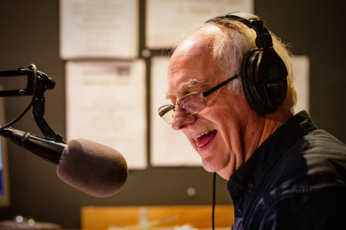 An elderly caucasian man DJs and presents his music show on live radio in Castlemaine, Australia - Australian Stock Image