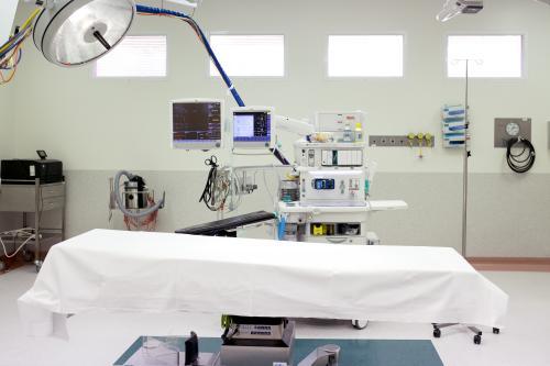 An empty bed with machines in the operating theatre in a hospital - Australian Stock Image