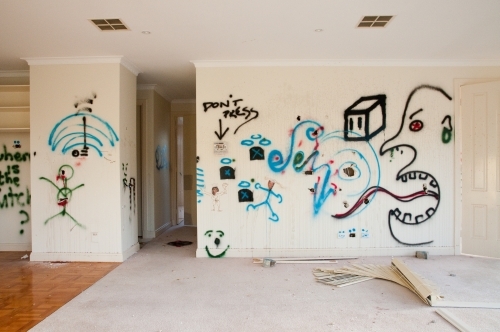 An empty, modern house with graffiti on the walls
