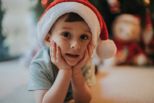 An innocent face and happy boy indoors at Christmas - Australian Stock Image