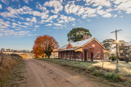 An old brick railway building with an autumn tree - Australian Stock Image
