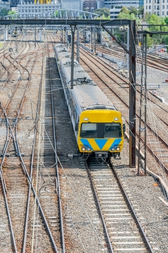 An oncoming commuter train going through a railway yard