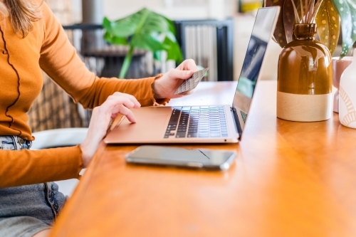 anonymous woman using credit card online - Australian Stock Image