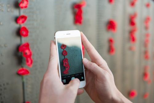 ANZAC DAY at the Australian War Memorial phone taking a photo of the wall - Australian Stock Image