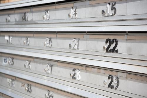 apartment block aluminium mailboxes with worn numbers - Australian Stock Image