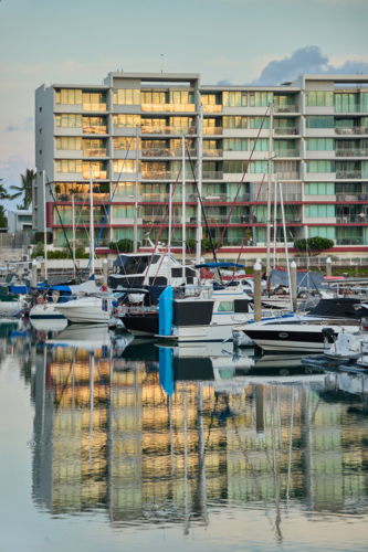 Apartments reflected in water of marina with boats - Australian Stock Image