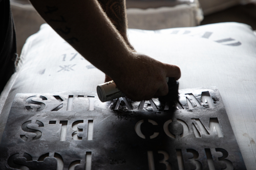 Applying a stencil to a bale of wool - Australian Stock Image
