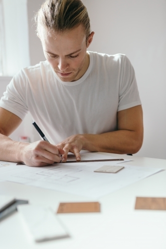 Architect using a ruler to draw a floor plan - Australian Stock Image