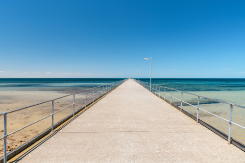 Ardrossan Jetty on a bright day against blue sky, Yorke Peninsula, South Australia - Australian Stock Image