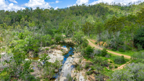 Area surrounding a freshwater swimming hole in the summer - Australian Stock Image