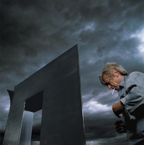 Artist and sculpture with stormy sky