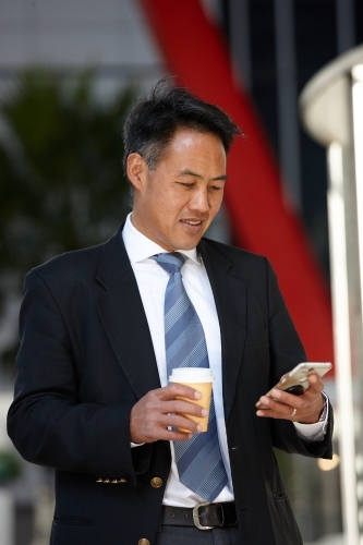 Asian businessman in city - Australian Stock Image